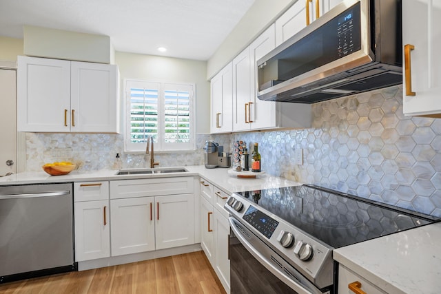 kitchen featuring tasteful backsplash, sink, white cabinets, and stainless steel appliances