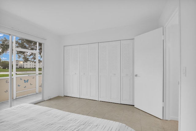 unfurnished bedroom featuring a closet and light tile patterned floors