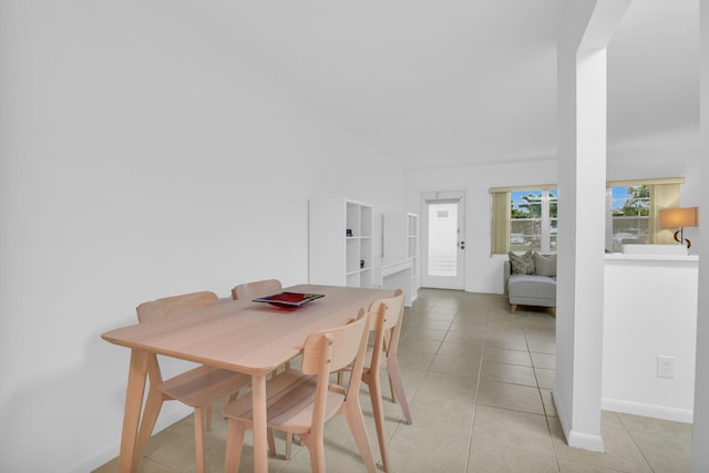 dining area with light tile patterned flooring and lofted ceiling