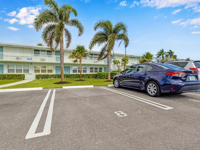 view of parking / parking lot with a lawn