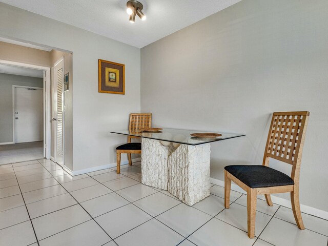 tiled dining area with a textured ceiling