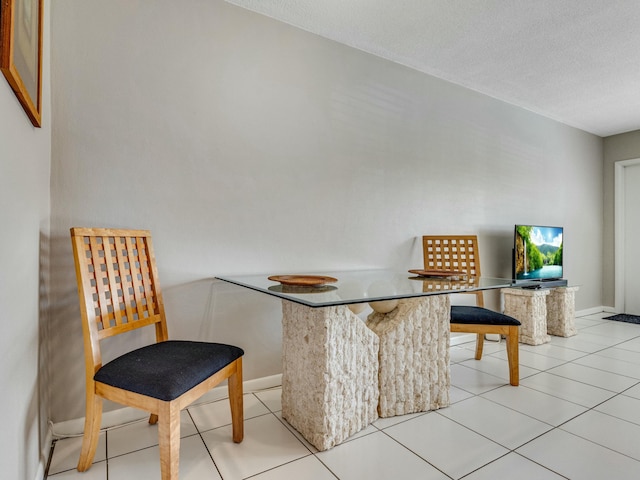 tiled dining area featuring a textured ceiling