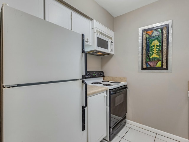 kitchen with white cabinets, light tile patterned flooring, and white appliances