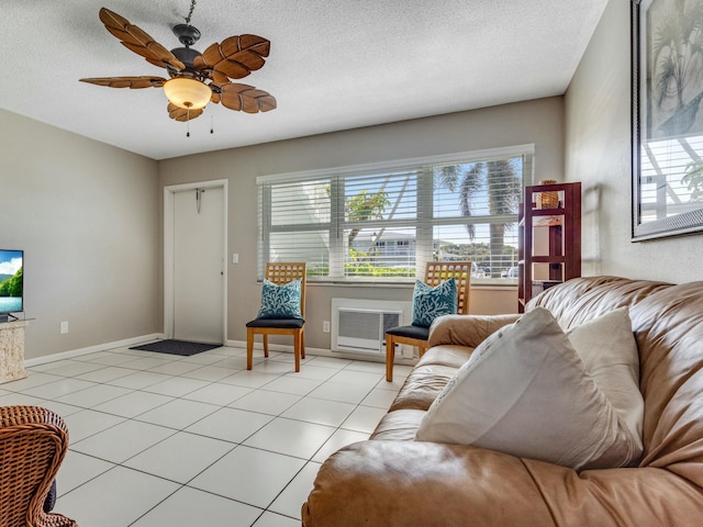 living room with a wall mounted air conditioner, light tile patterned flooring, and a textured ceiling