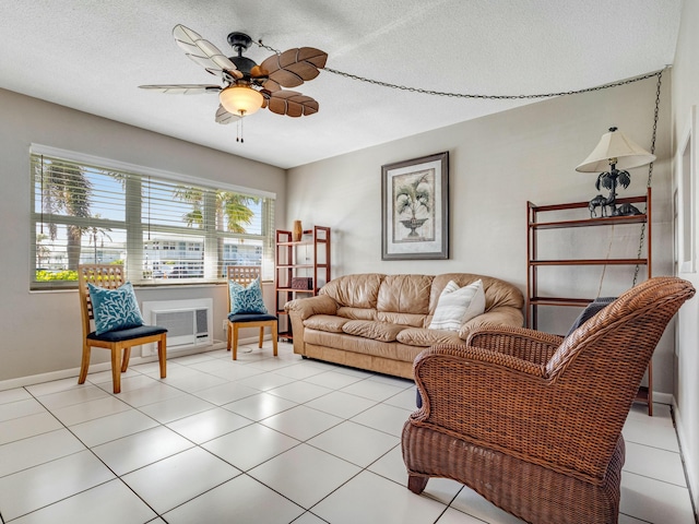 living room featuring ceiling fan, light tile patterned floors, and a textured ceiling