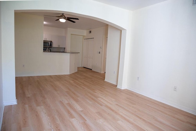 unfurnished living room featuring ceiling fan and light hardwood / wood-style floors