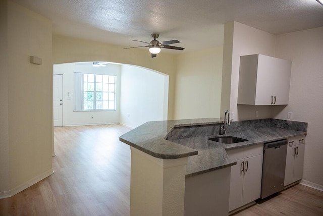 kitchen featuring sink, stainless steel dishwasher, kitchen peninsula, and white cabinets