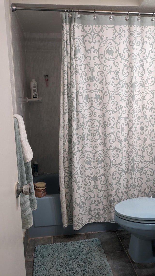 bathroom featuring toilet, shower / bath combo with shower curtain, and tile patterned floors