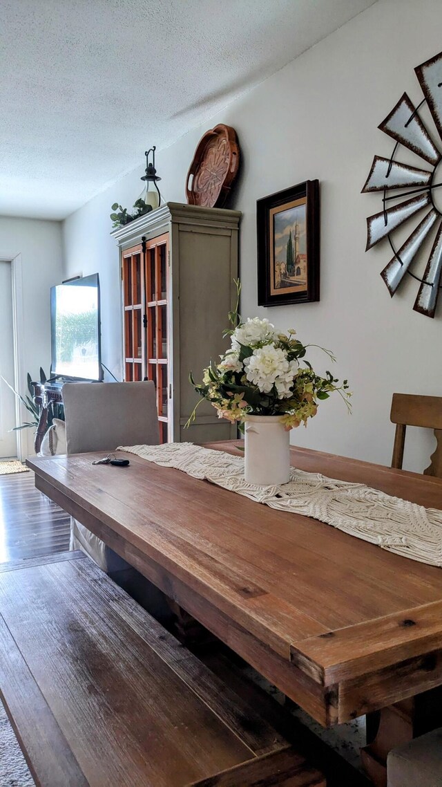 dining room featuring a textured ceiling and wood finished floors