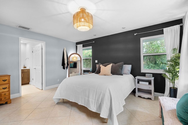 tiled bedroom with connected bathroom and multiple windows