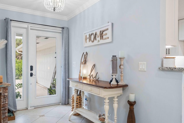 entrance foyer with a notable chandelier, plenty of natural light, ornamental molding, and light tile patterned floors