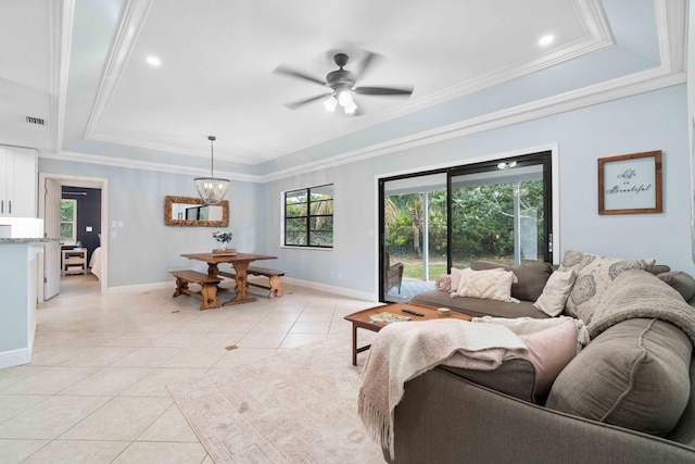 living room with a tray ceiling, light tile patterned floors, and ornamental molding