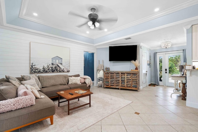 tiled living room featuring a tray ceiling, crown molding, and ceiling fan with notable chandelier