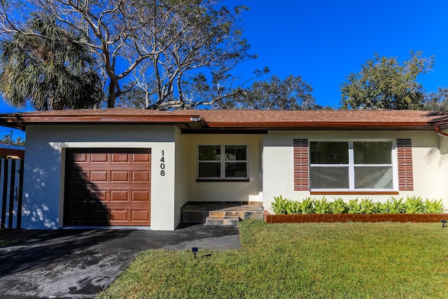 ranch-style home featuring a front lawn and a garage