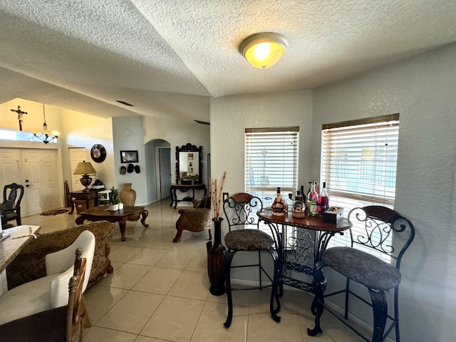 dining room with light tile patterned floors, a textured ceiling, and an inviting chandelier