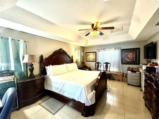 bedroom featuring a tray ceiling, ceiling fan, and light tile patterned floors