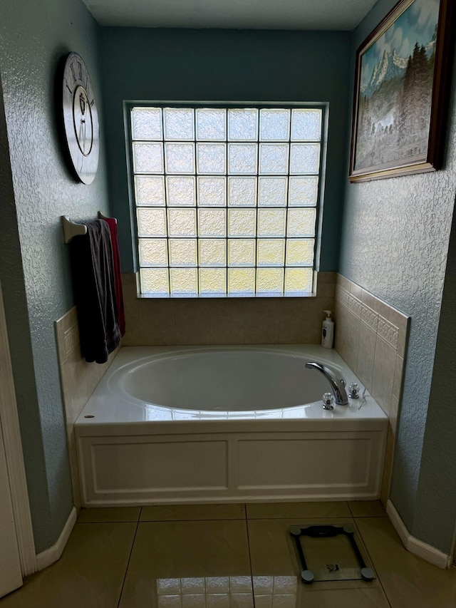 bathroom with tile patterned floors, a tub, and plenty of natural light