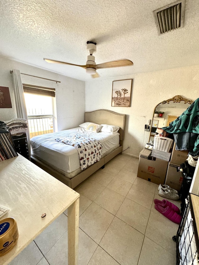 tiled bedroom featuring ceiling fan and a textured ceiling