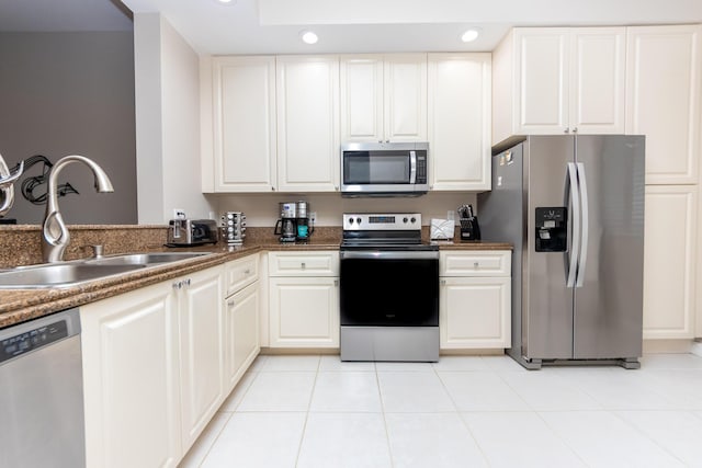 kitchen with white cabinets, light tile patterned flooring, sink, and appliances with stainless steel finishes