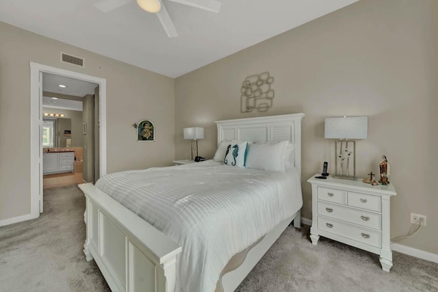 bedroom featuring connected bathroom, ceiling fan, and light carpet