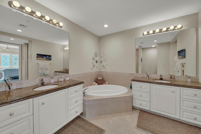 bathroom featuring tile patterned floors, vanity, and tiled bath