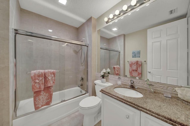 full bathroom with toilet, vanity, a textured ceiling, and combined bath / shower with glass door