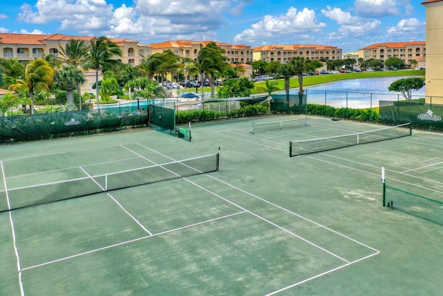 view of tennis court featuring a water view