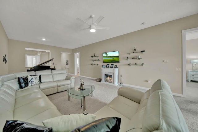 carpeted living room with ceiling fan and a high end fireplace