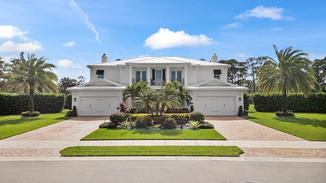 view of front of home featuring a front lawn, a garage, and a balcony