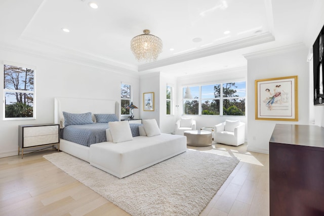 bedroom with a raised ceiling, light wood-type flooring, a notable chandelier, and crown molding