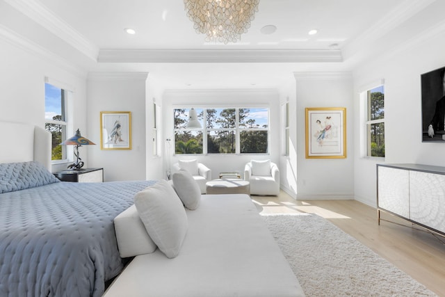 bedroom featuring light hardwood / wood-style floors, multiple windows, a raised ceiling, and a chandelier