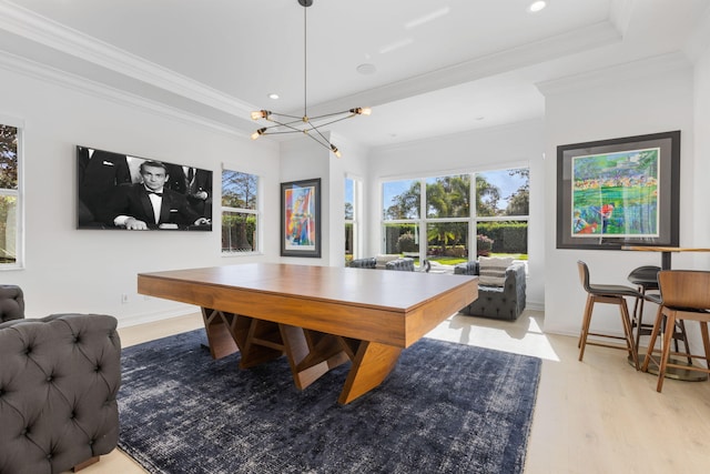 dining room featuring light wood-type flooring, a chandelier, and crown molding