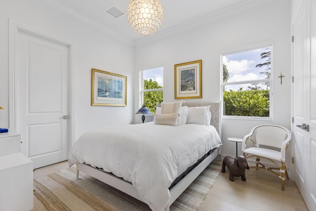 bedroom with ornamental molding and an inviting chandelier