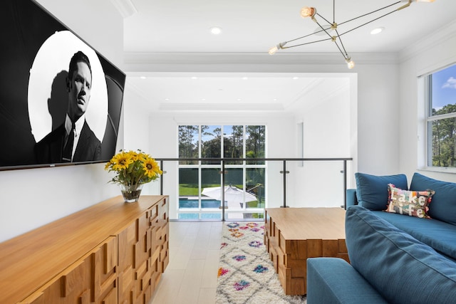 living room featuring a chandelier, light hardwood / wood-style floors, and ornamental molding