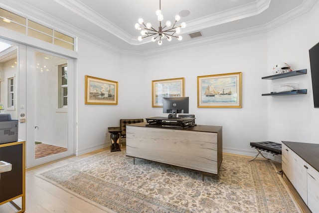 office space with hardwood / wood-style floors, ornamental molding, a raised ceiling, and a chandelier