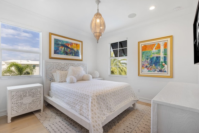 bedroom featuring light wood-type flooring and crown molding