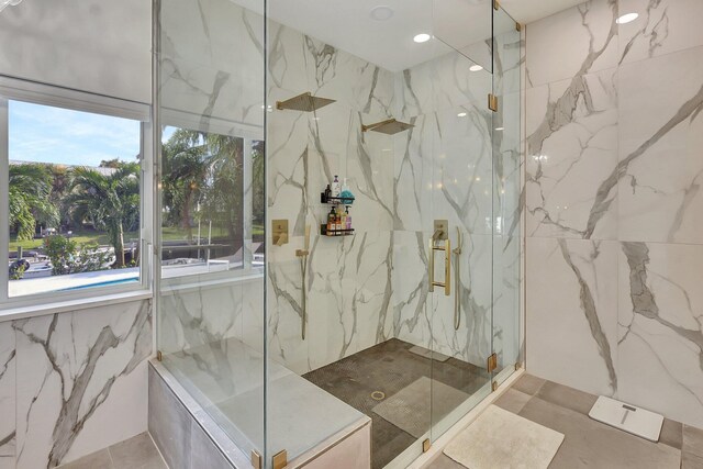 bathroom with an enclosed shower and tile walls