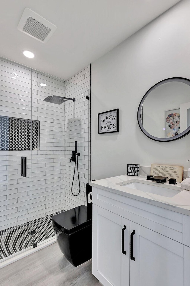 bathroom featuring hardwood / wood-style floors, vanity, and an enclosed shower