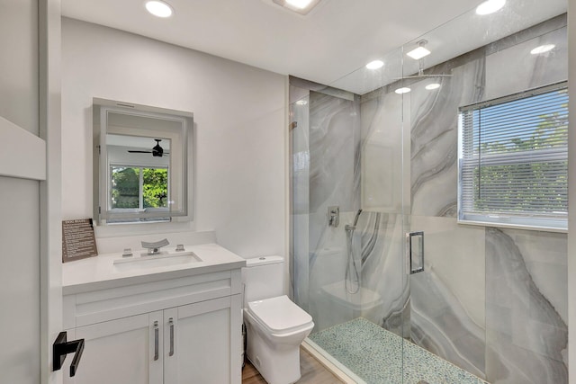 bathroom featuring vanity, hardwood / wood-style flooring, ceiling fan, toilet, and an enclosed shower