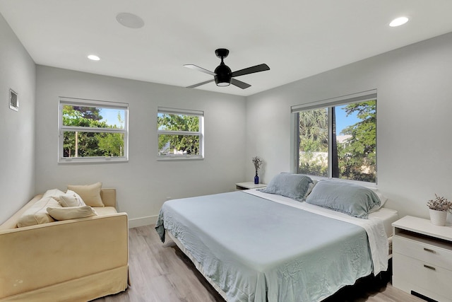 bedroom featuring multiple windows, ceiling fan, and light hardwood / wood-style flooring