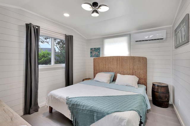 bedroom with a wall mounted AC, light hardwood / wood-style flooring, vaulted ceiling, and multiple windows