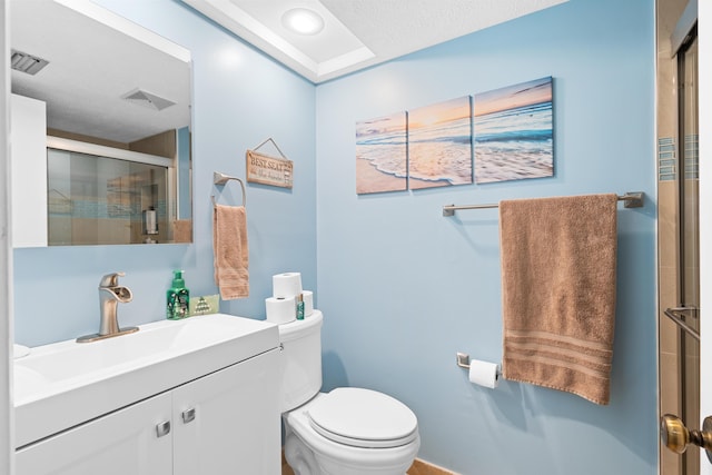 bathroom featuring vanity, toilet, and an enclosed shower