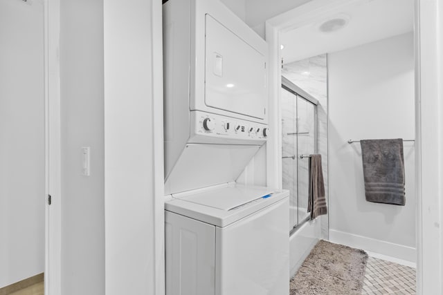 washroom featuring stacked washer and dryer and light tile patterned floors