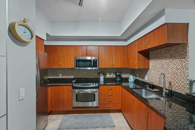 kitchen with decorative backsplash, light tile patterned floors, stainless steel appliances, and sink