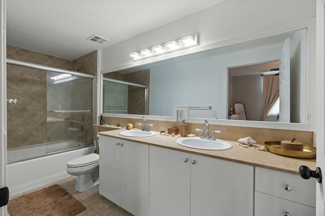 full bathroom with shower / bath combination with glass door, tile patterned flooring, vanity, and toilet