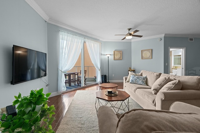 living room featuring a textured ceiling, ceiling fan, wood-type flooring, and crown molding