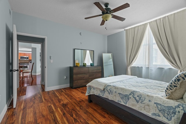 bedroom featuring ceiling fan, dark hardwood / wood-style flooring, and a textured ceiling