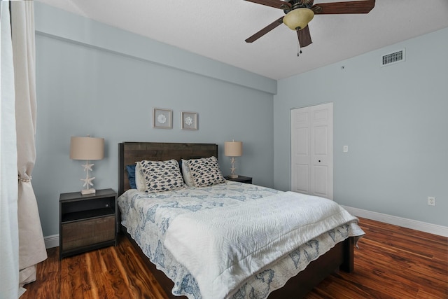 bedroom featuring dark hardwood / wood-style flooring, ceiling fan, and a closet