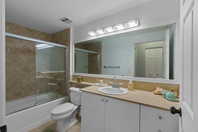 full bathroom featuring toilet, vanity, tile patterned floors, and shower / bath combination with glass door