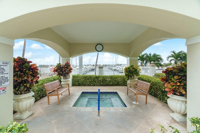 view of pool featuring a water view and a patio